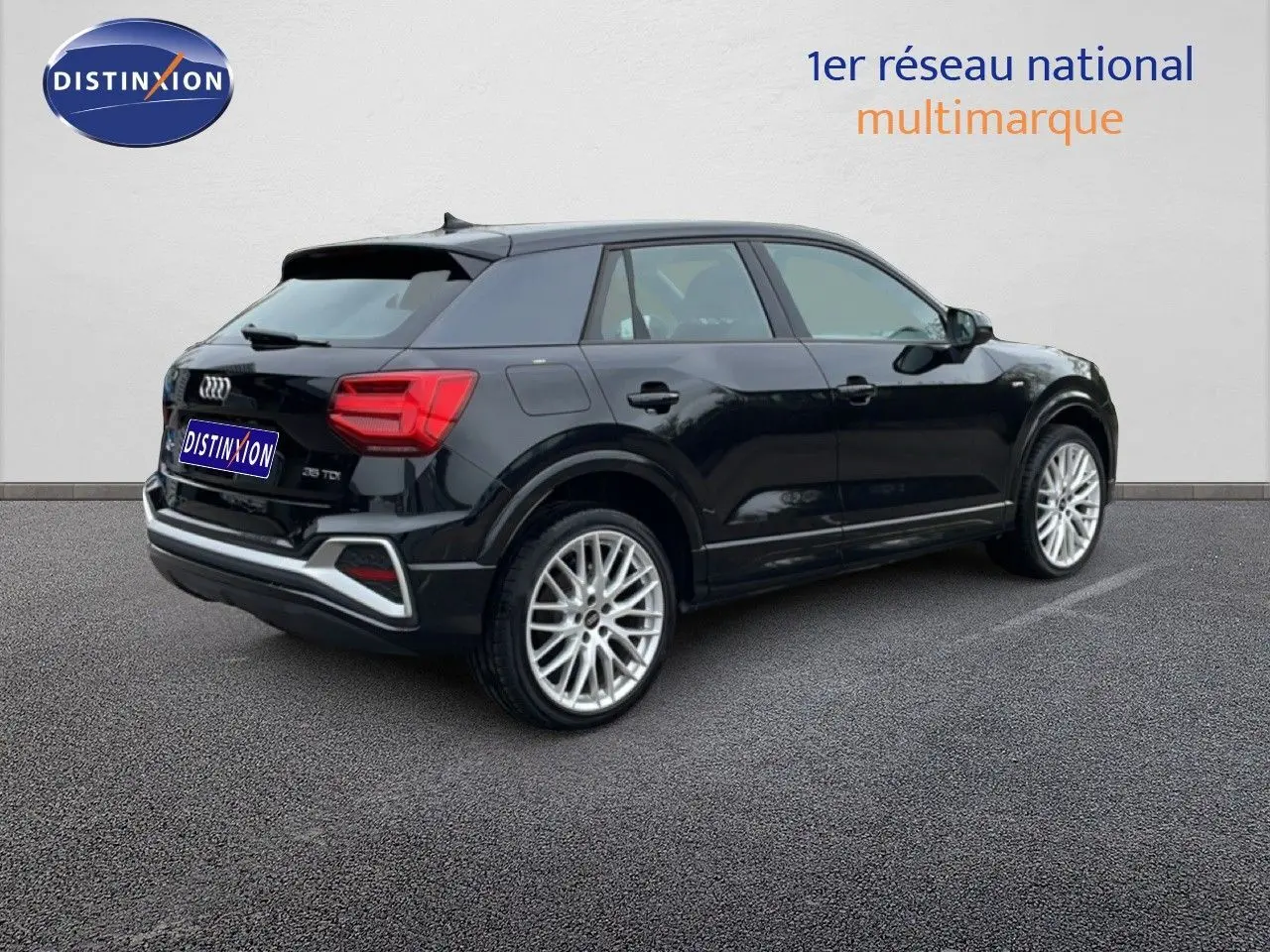 Audi Q2 noir mito metal vue 3/4 arrière droit, jantes alliage et feux arrière LED visibles.
