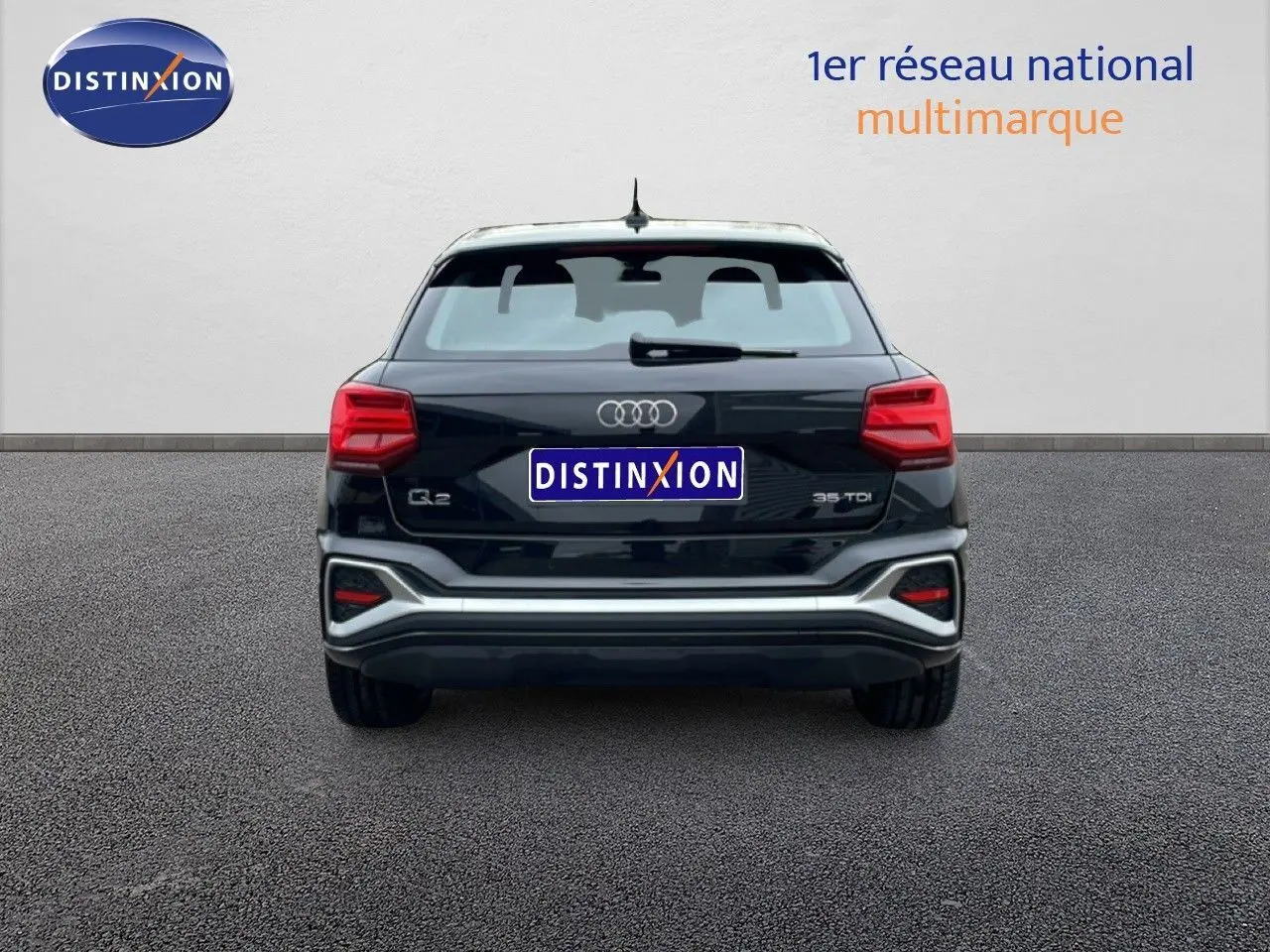 Vue arrière d'un Audi Q2 noir mito metal 2025 avec feux rouges et logo distinctif sur fond neutre.