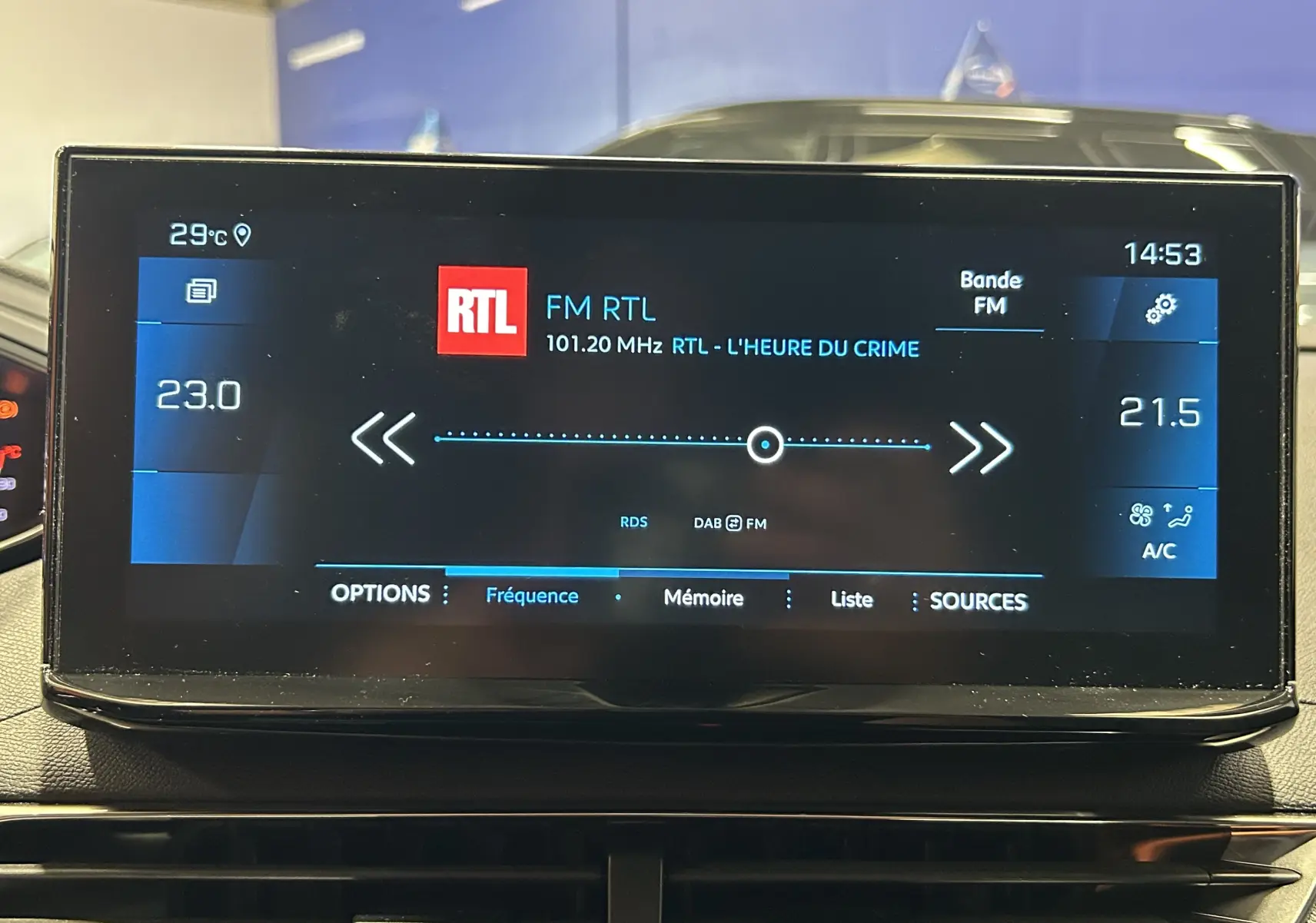 Écran tactile central du Peugeot 5008 2024 affichant la radio FM RTL et la climatisation en intérieur noir.