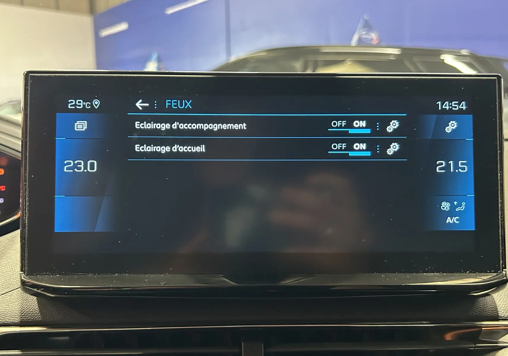 Écran tactile central du Peugeot 5008 2024 affichant les réglages des feux avec climatisation à 23°C et 21,5°C.