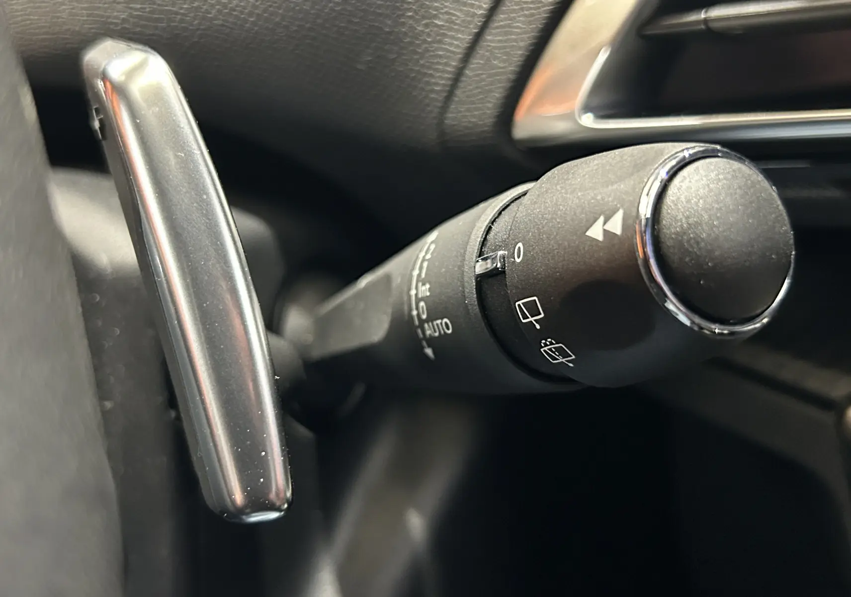 Gros plan sur la commande de l’essuie-glace du Peugeot 5008 2024, intérieur noir avec détails chromés.