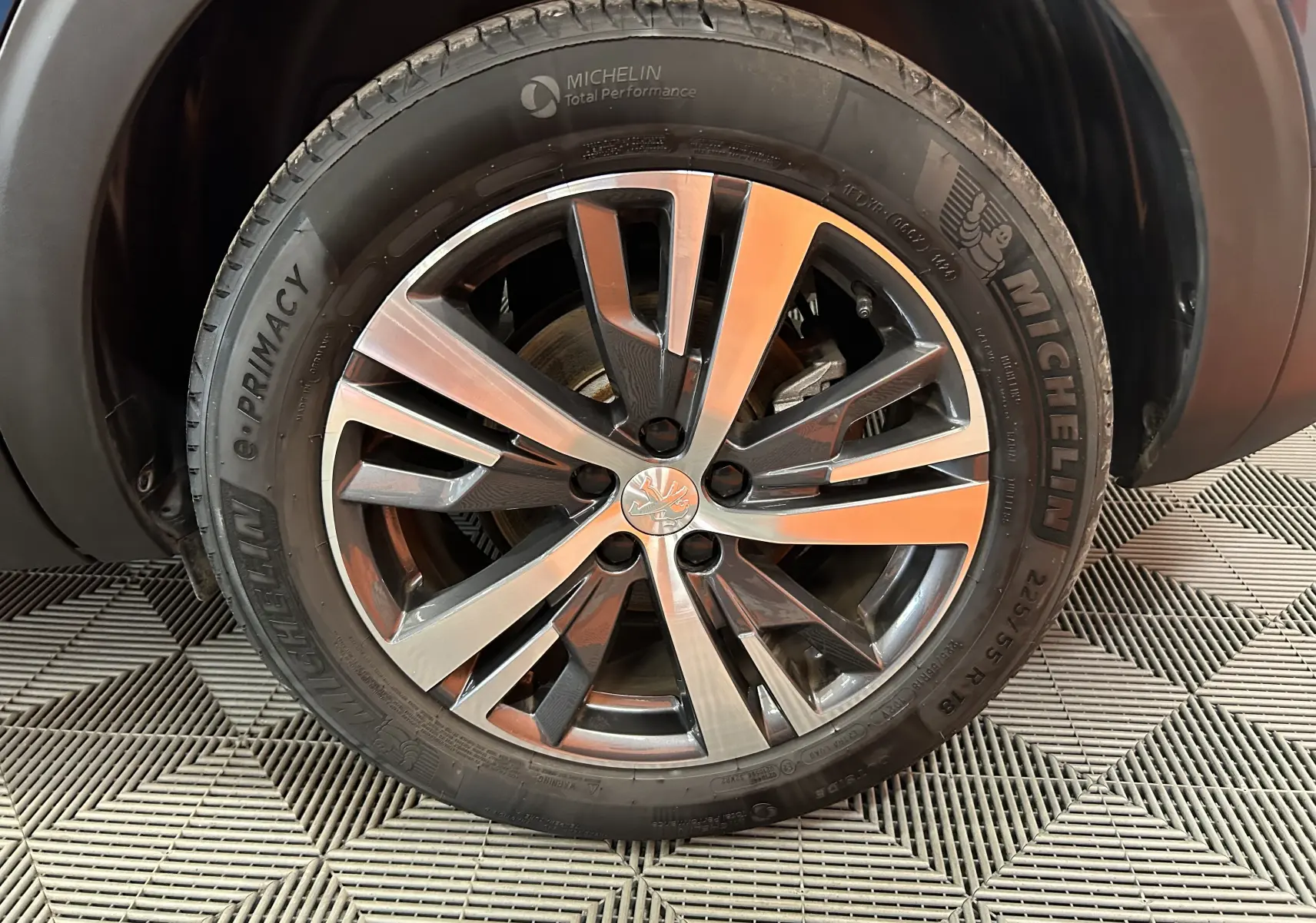 Gros plan sur la jante alliage bicolore et pneu Michelin d'un Peugeot 5008 Bleu Célèbes, côté avant droit.