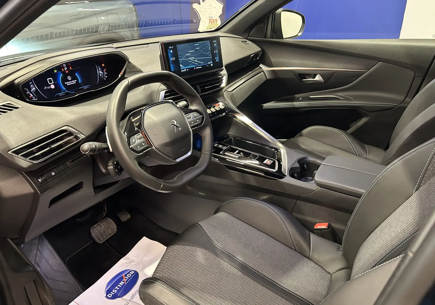Intérieur avant droit du Peugeot 5008 2024, tableau de bord numérique et écran tactile central avec sellerie noire.