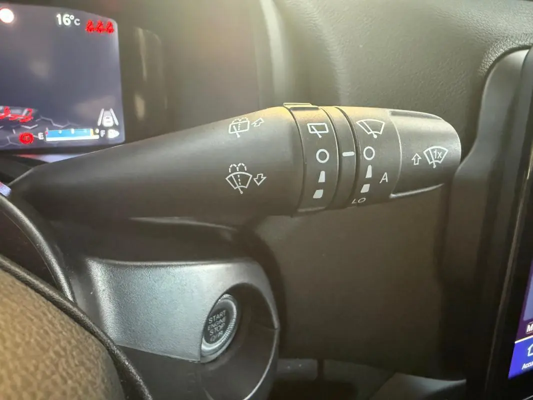 Gros plan sur la commande des essuie-glaces à gauche du volant dans un Jeep Renegade gris anthracite 2024 e-Hybrid Summit.