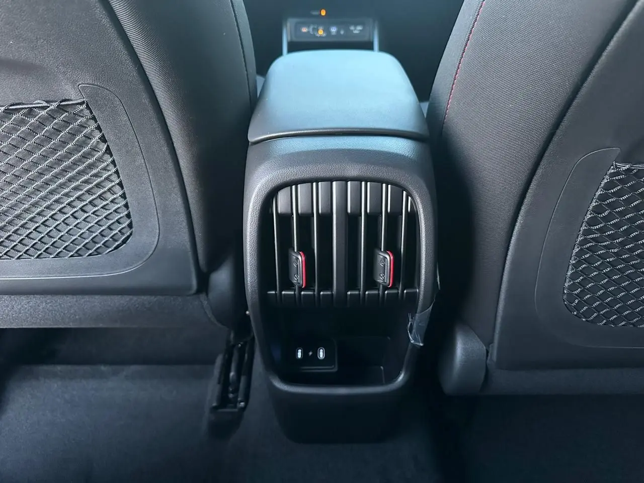 Vue rapprochée de la console centrale arrière du Hyundai Kona 2026 gris, avec bouches d’aération et prises USB-C visibles.