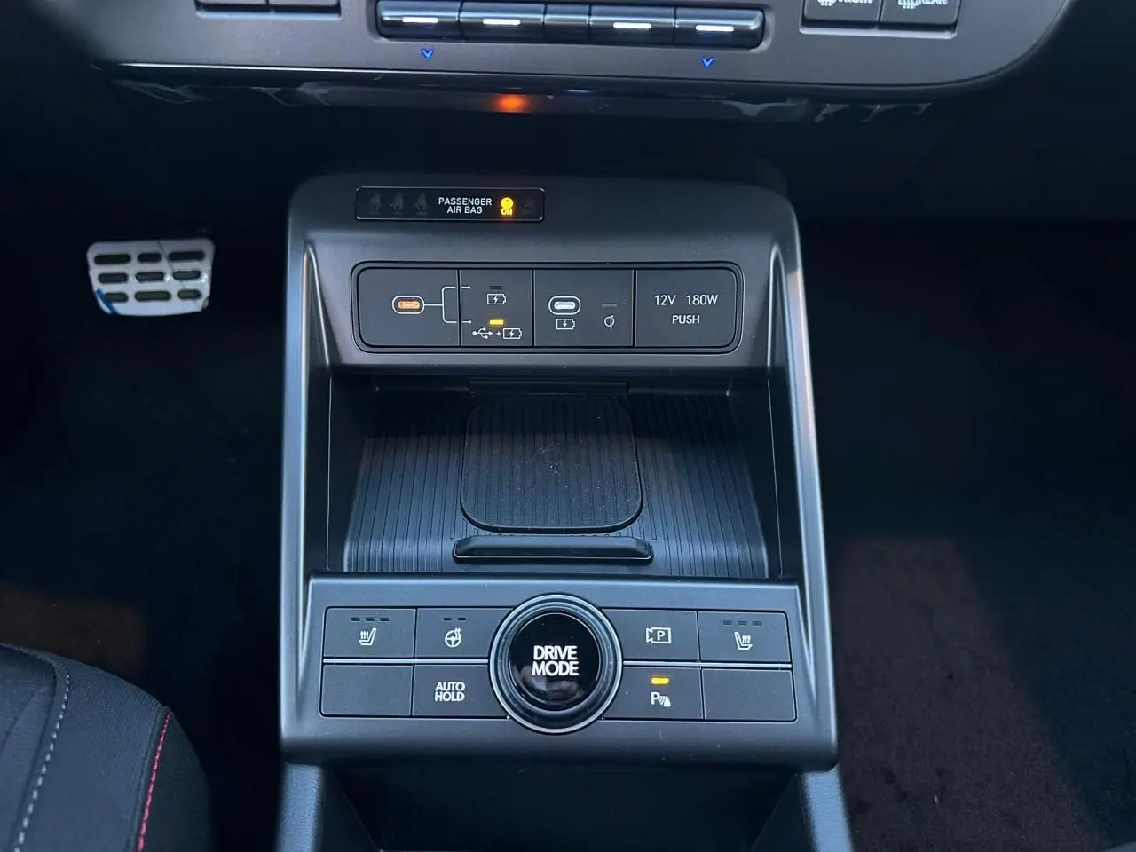 Vue rapprochée de la console centrale du Hyundai KONA II 1.6 Hybrid N Line, avec commandes de modes de conduite et prises USB-C.
