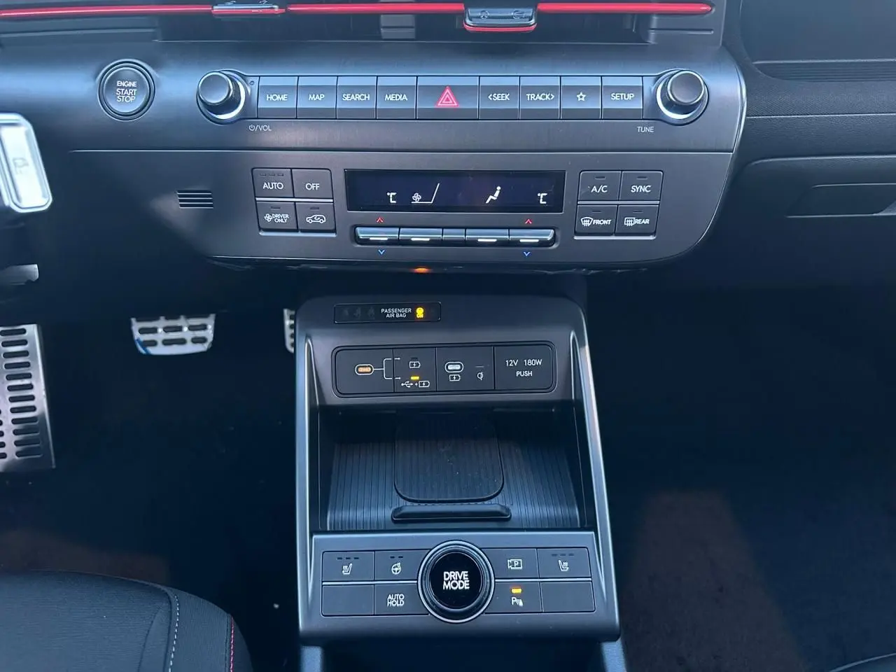 Vue intérieure centrée sur la console centrale du Hyundai Kona 2026 gris, avec commandes climatisation et ports USB-C visibles.