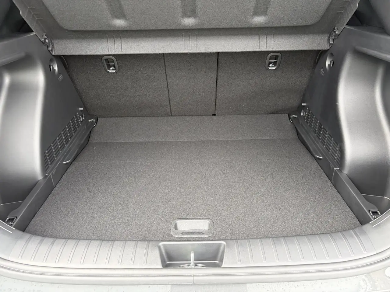 Coffre ouvert de Hyundai Kona 2026 gris Ecotronic, montrant un espace de chargement propre et bien fini.
