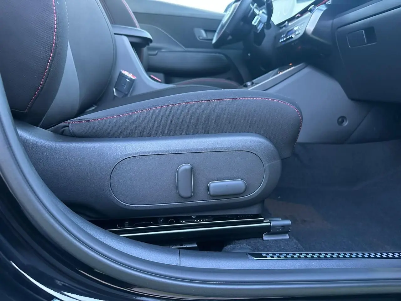 Vue intérieure côté gauche du siège avant noir avec surpiqûres rouges du Hyundai Kona II 1.6 Hybrid N Line 2026.