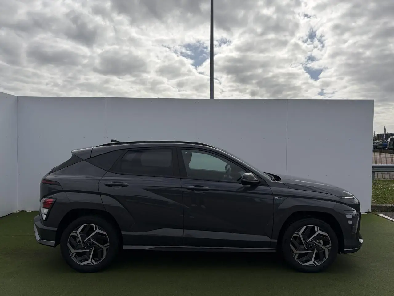 Vue de profil côté gauche d'un Hyundai Kona II 1.6 Hybrid N Line gris métallisé Ecotronic avec jantes alliage 18 pouces.