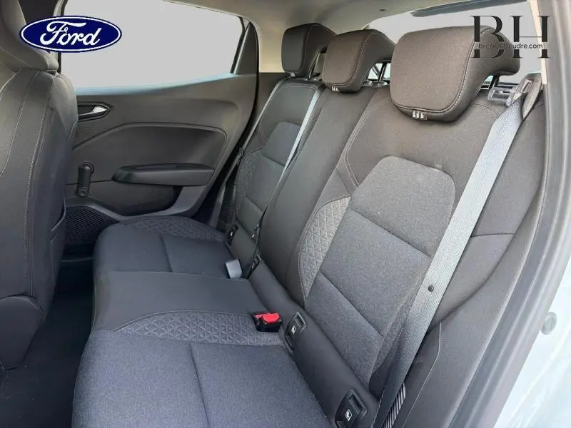 Vue intérieure côté droit montrant la banquette arrière en tissu noir avec motifs surpiqués d'une Renault Clio blanche.