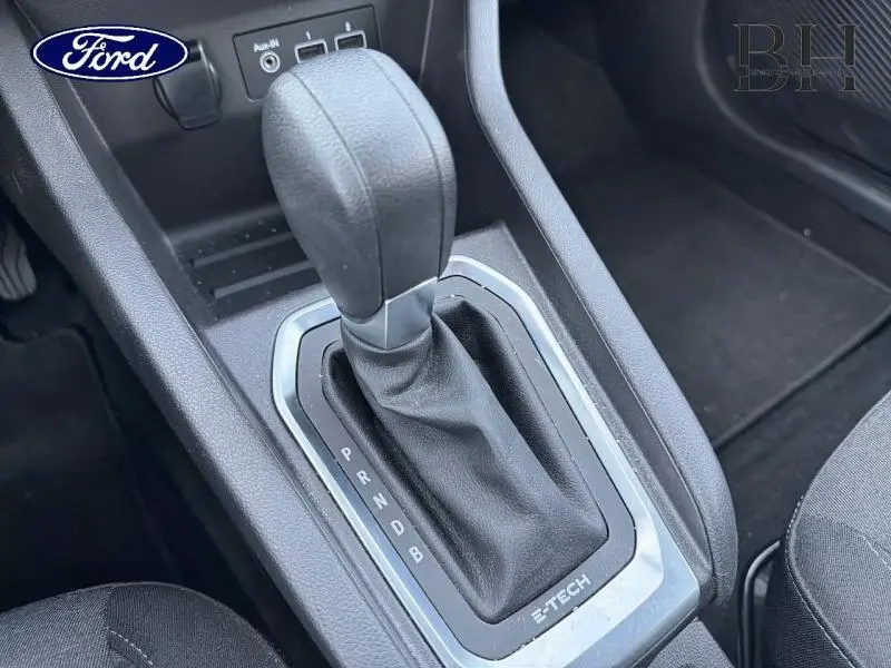 Gros plan sur la commande de boîte automatique noire avec marquage E-Tech dans l'habitacle d'une Renault Clio blanche.