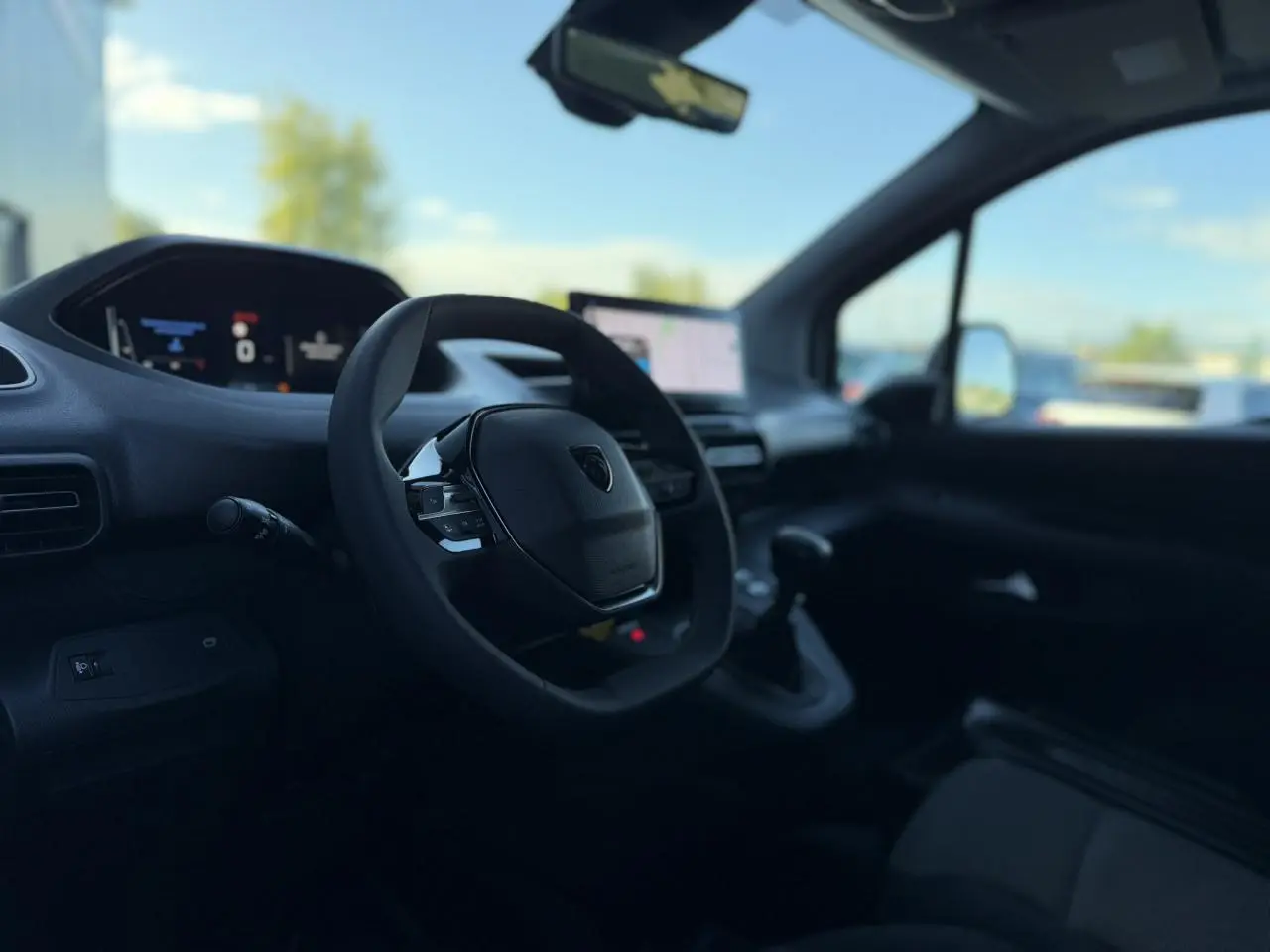 Vue intérieure côté conducteur du Peugeot Partner 2026, avec tableau de bord numérique et écran tactile central.