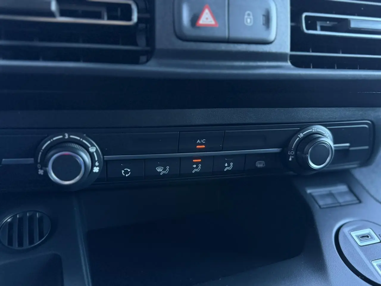 Gros plan sur la console centrale noire du Peugeot Partner 2026 avec commandes climatisation et ventilation.