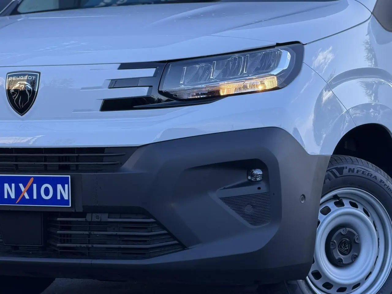 Gros plan sur l'avant droit blanc Icy du Peugeot Partner 2026 avec phare LED et pare-chocs noir mat.