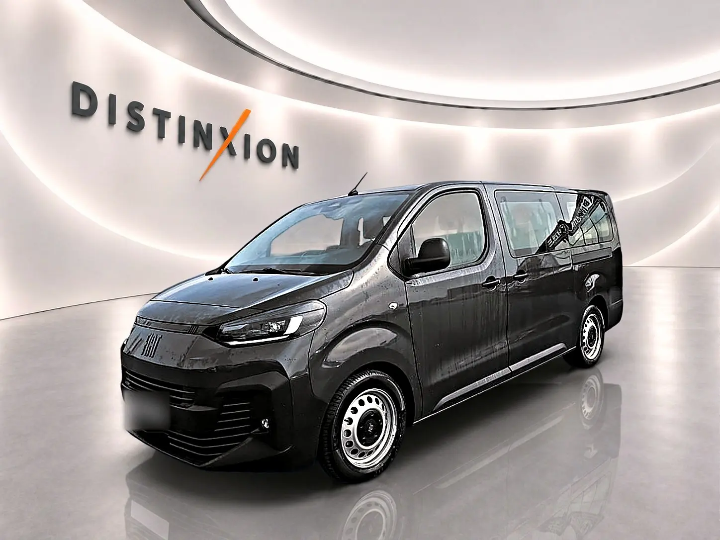 Vue 3/4 avant droite du FIAT Scudo Combi gris titane avec porte latérale coulissante dans un showroom lumineux.