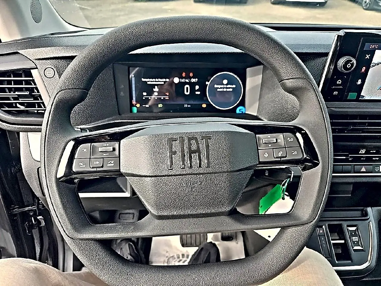 Vue rapprochée du volant FIAT avec commandes intégrées et tableau de bord numérique du Scudo Combi gris titane.