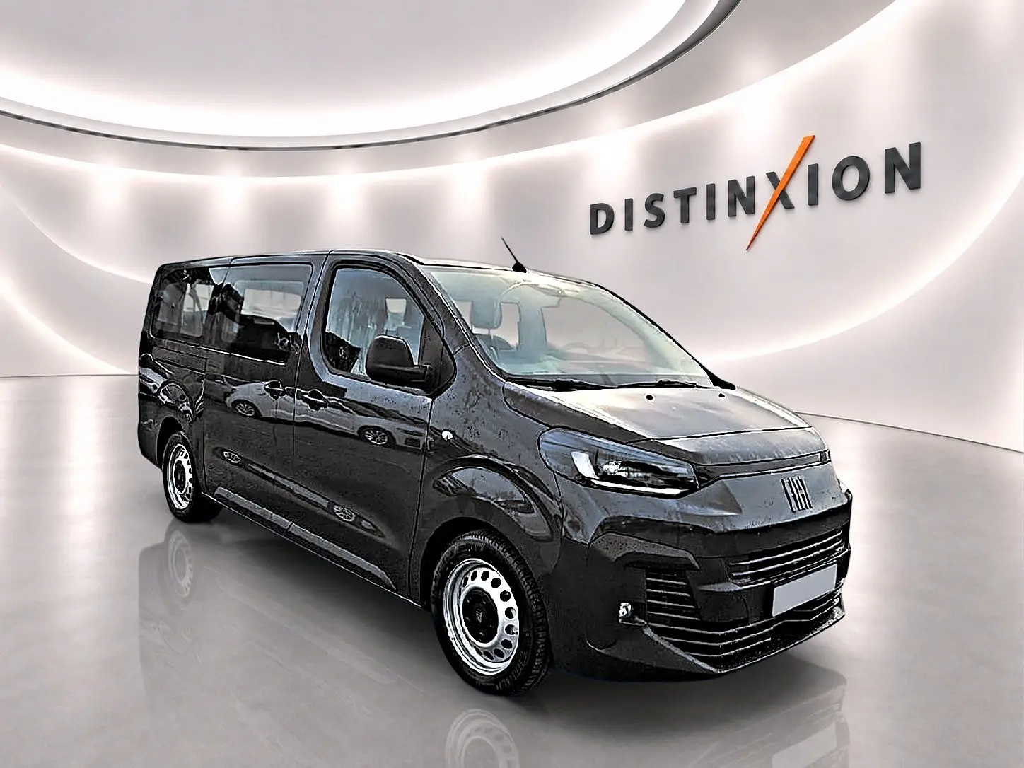 Vue 3/4 avant droit du FIAT Scudo Combi gris titane avec porte latérale coulissante en showroom lumineux.