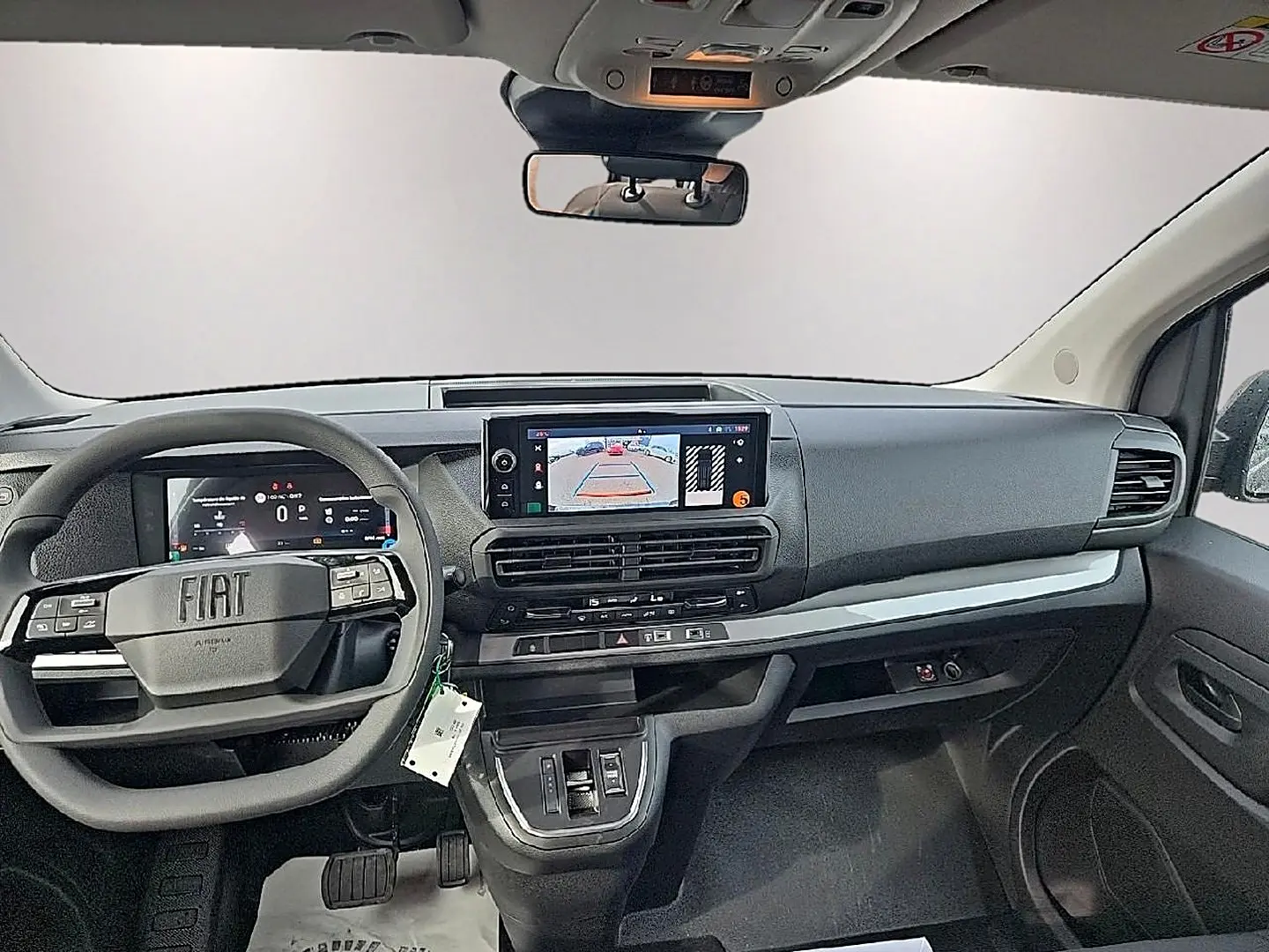 Vue intérieure avant du Fiat Scudo Combi gris titane 2026, tableau de bord moderne avec écran tactile et volant multifonction.