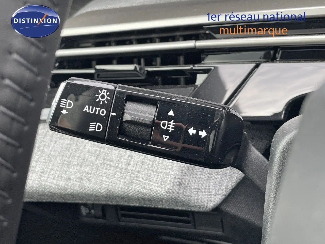 Gros plan sur la commande des feux et clignotants du Peugeot 3008 Hybrid 2025, intérieur gris et noir.