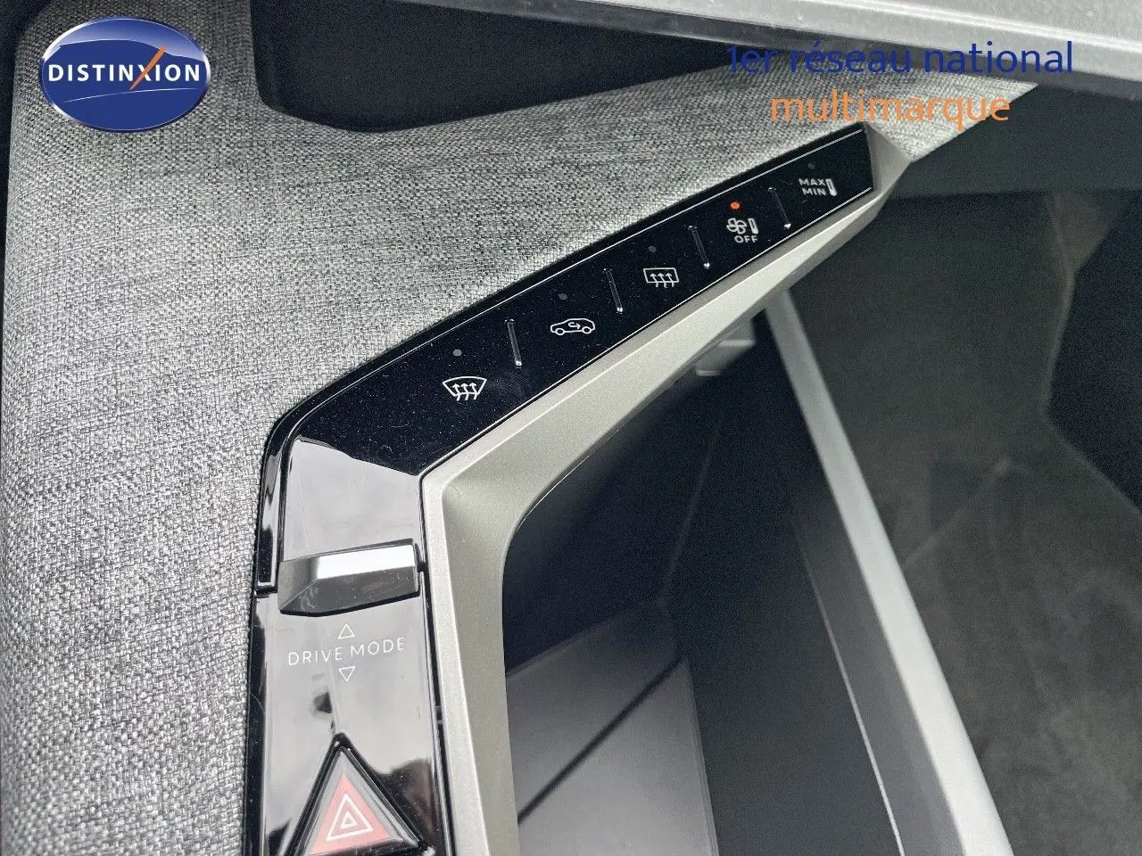 Gros plan sur la console centrale du Peugeot 3008 Hybrid 2025, avec commandes tactiles et bouton Drive Mode.