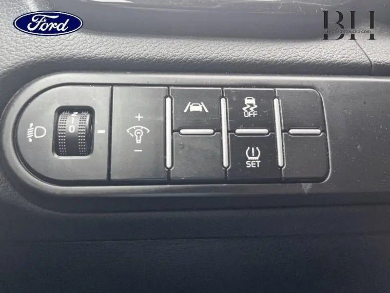 Gros plan sur les commandes de réglage d'éclairage et d'assistance à la conduite dans une Kia CEE'D SW noire Basalte 2023.