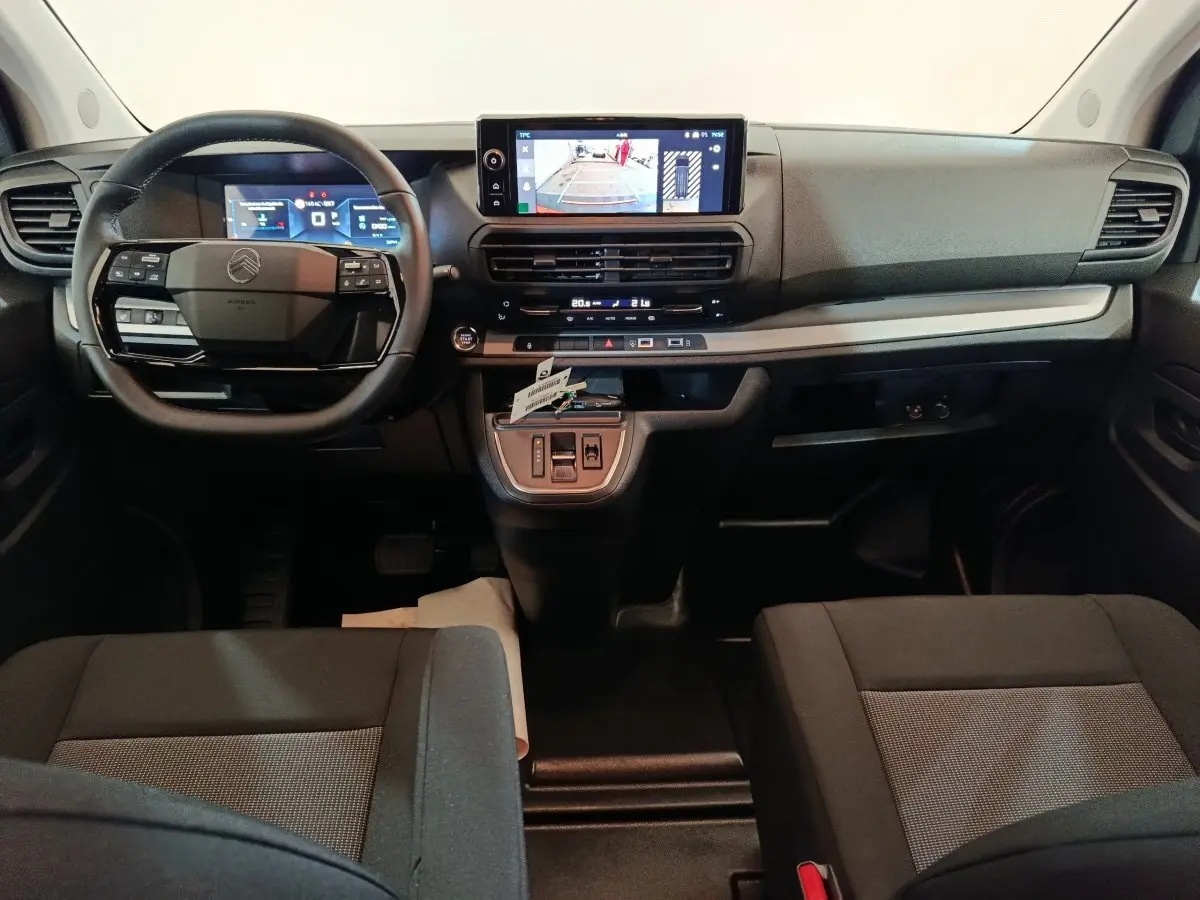 Vue intérieure avant du Citroën Jumpy XL 2025 noir, tableau de bord avec écran tactile et volant multifonction.