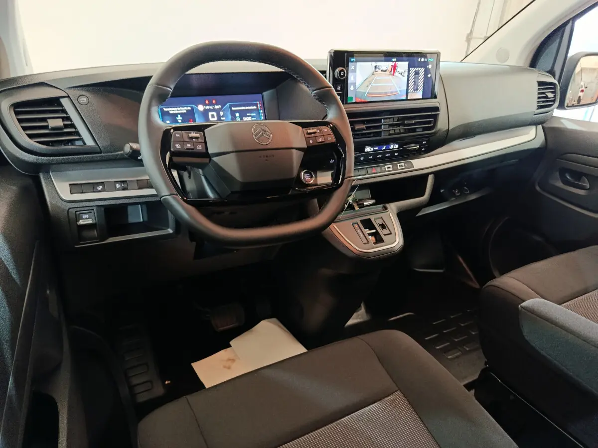 Intérieur du Citroën Jumpy XL 2025 vu de face, tableau de bord noir avec écran tactile et volant multifonctions.