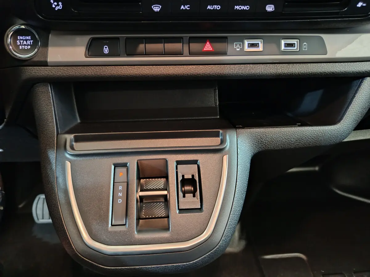 Vue rapprochée de la console centrale noire du Citroën Jumpy 2025 avec boutons de boîte auto et ports USB visibles.
