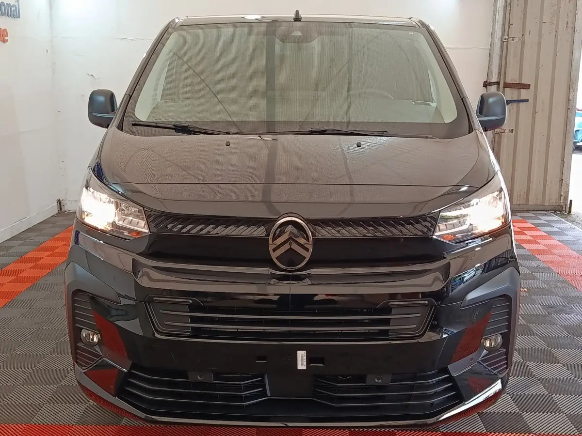 Vue avant du Citroën Jumpy XL noir 2025 avec phares allumés et calandre distinctive dans un garage.