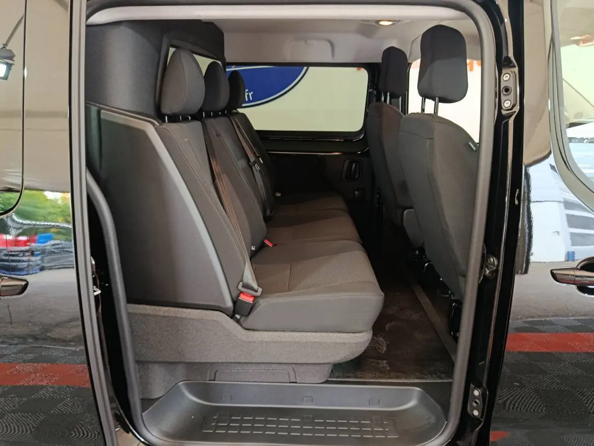 Vue latérale intérieure du Citroën Jumpy XL noir, montrant la banquette arrière 3 places et la cloison vitrée.