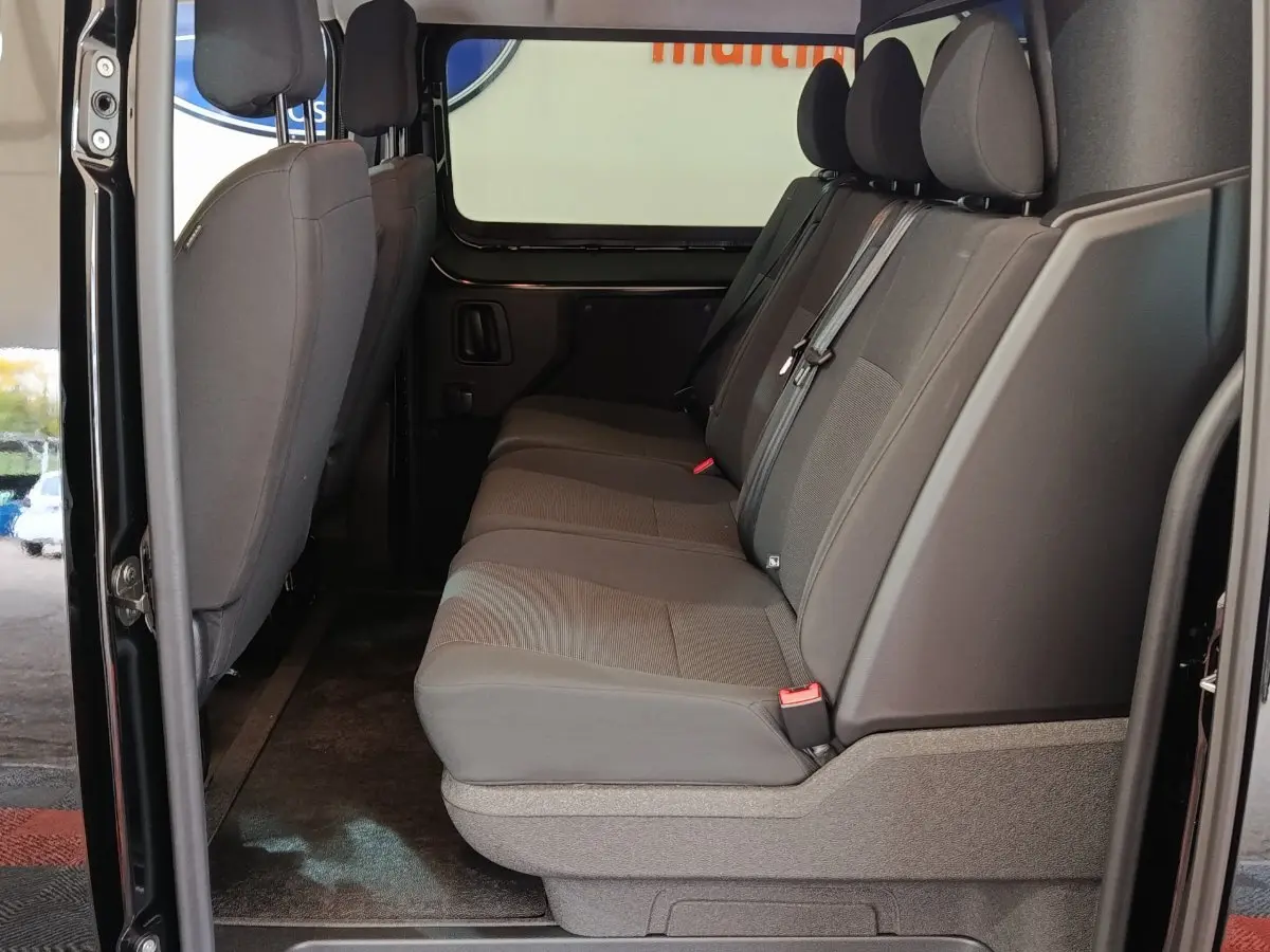 Vue latérale intérieure de la banquette arrière grise du Citroën Jumpy XL noir avec portes ouvertes.