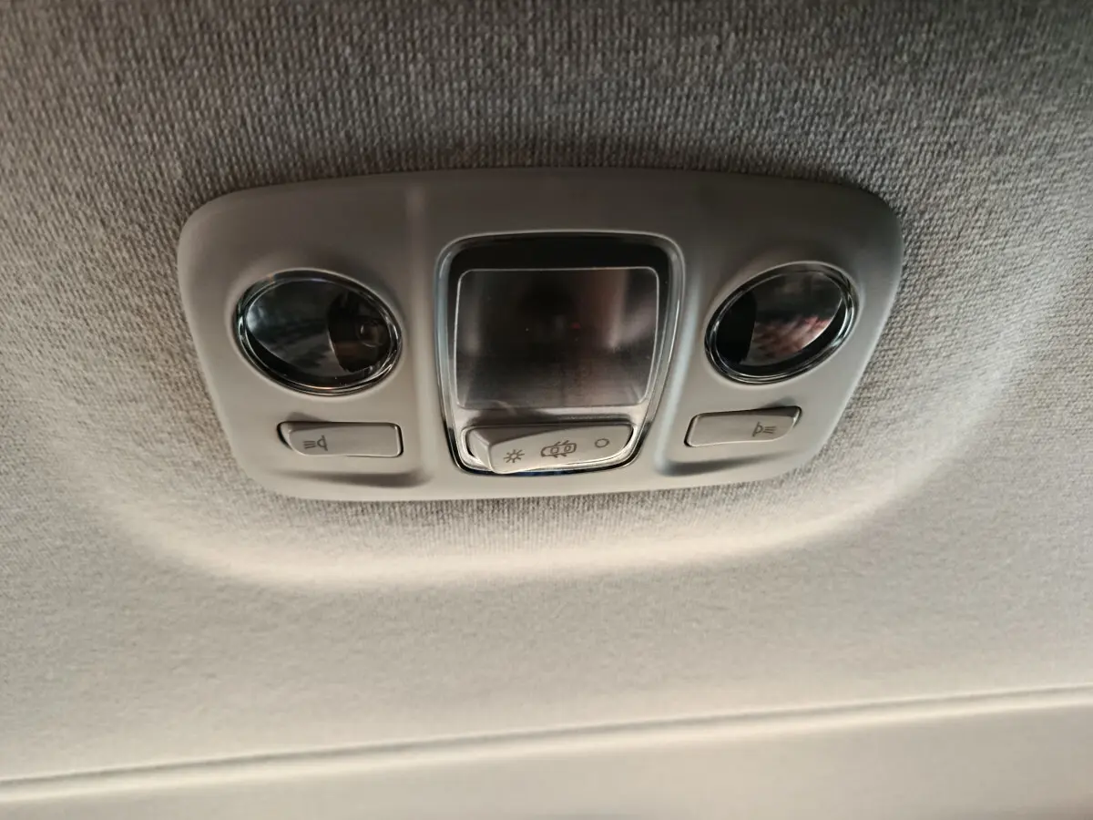 Plafonnier intérieur gris clair avec deux lampes rondes et boutons de commande dans un Citroën Jumpy XL noir.