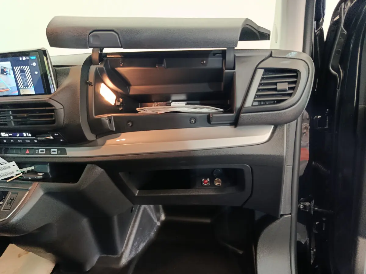 Intérieur du Citroën Jumpy XL 2025, vue côté passager avec boîte à gants ouverte et éclairage intérieur allumé.