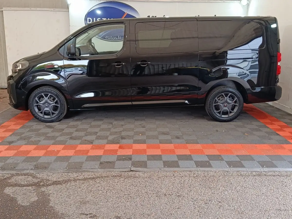 Profil droit d'un Citroën Jumpy XL noir 2025 avec jantes spécifiques et cloison vitrée visible à l'arrière.