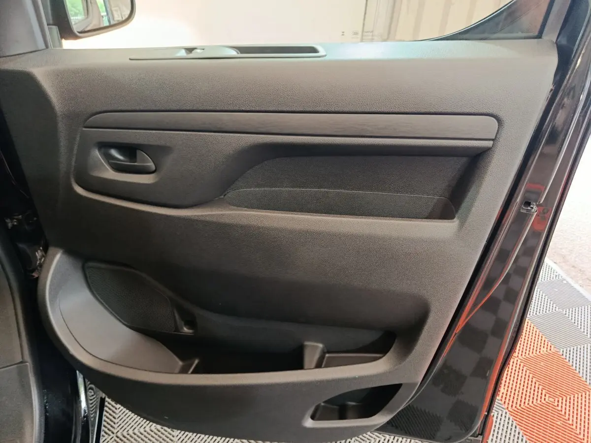 Vue intérieure de la porte avant droite noire du Citroën Jumpy XL 2025, avec poignée et rangement intégré.