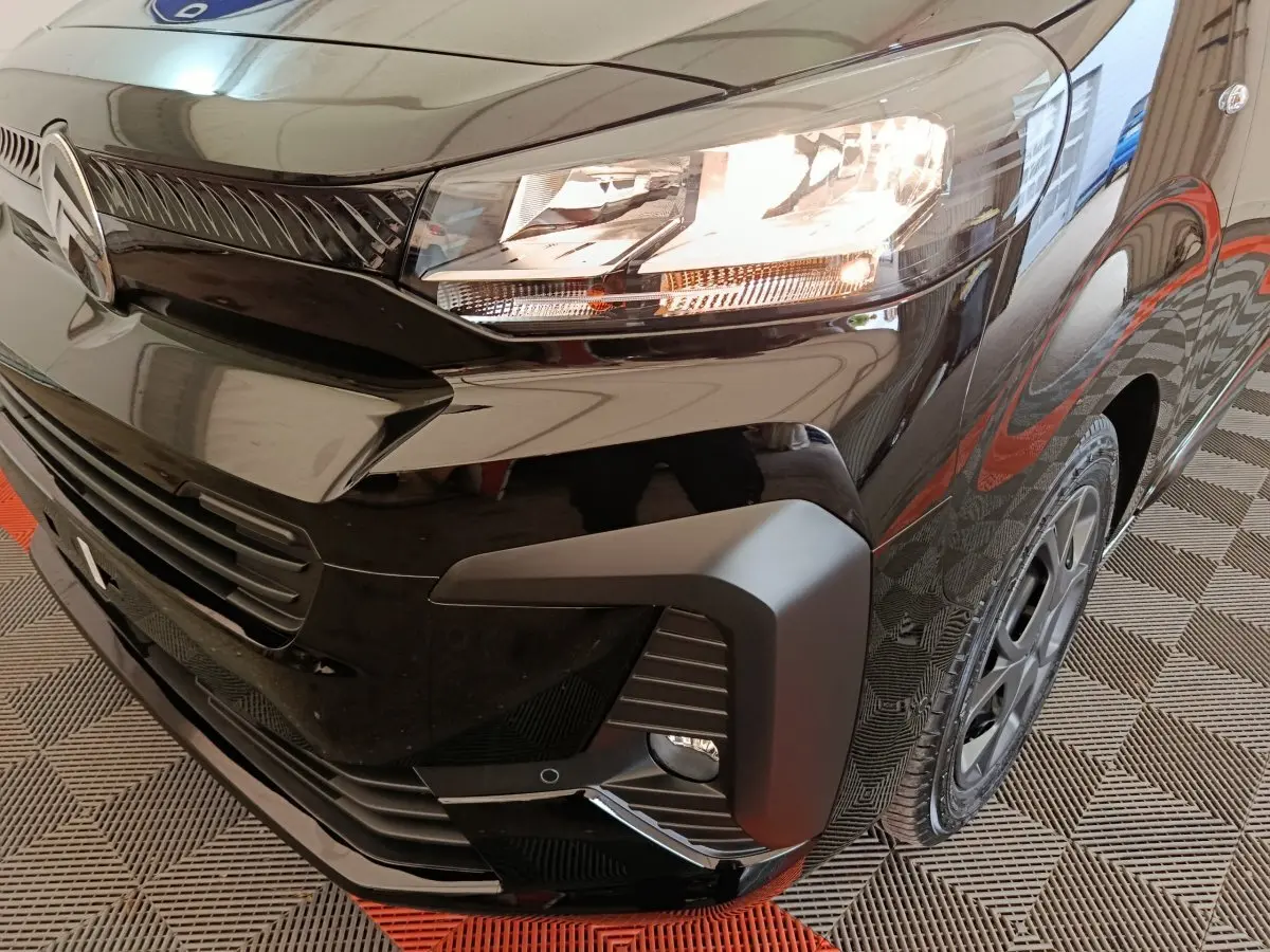 Gros plan sur l'avant droit noir brillant du Citroën Jumpy XL 2025, mettant en valeur le phare et la calandre.
