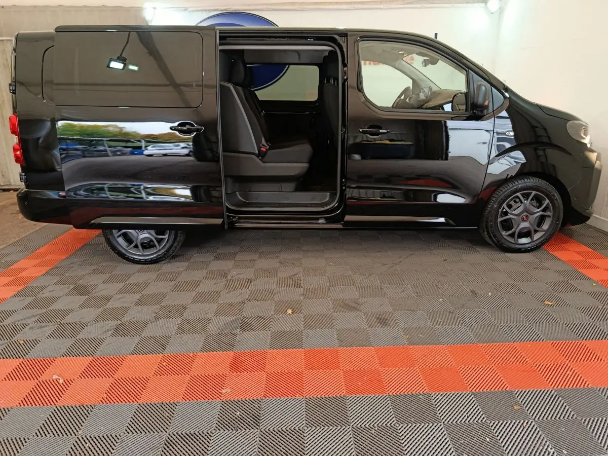 Profil gauche d’un Citroën Jumpy XL noir 2025 avec porte coulissante ouverte dévoilant la banquette arrière.