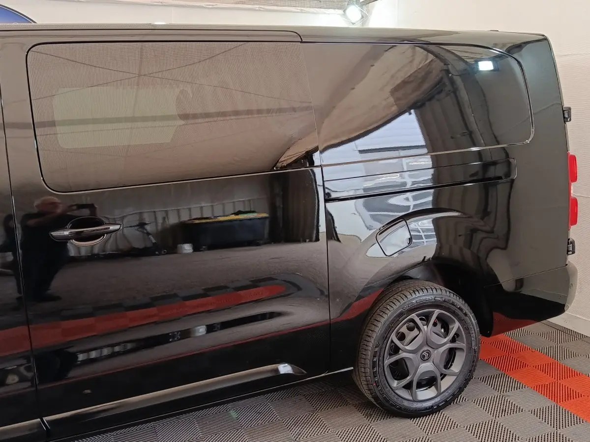 Vue latérale droite d’un Citroën Jumpy XL noir avec porte coulissante et jante alliage distinctive.
