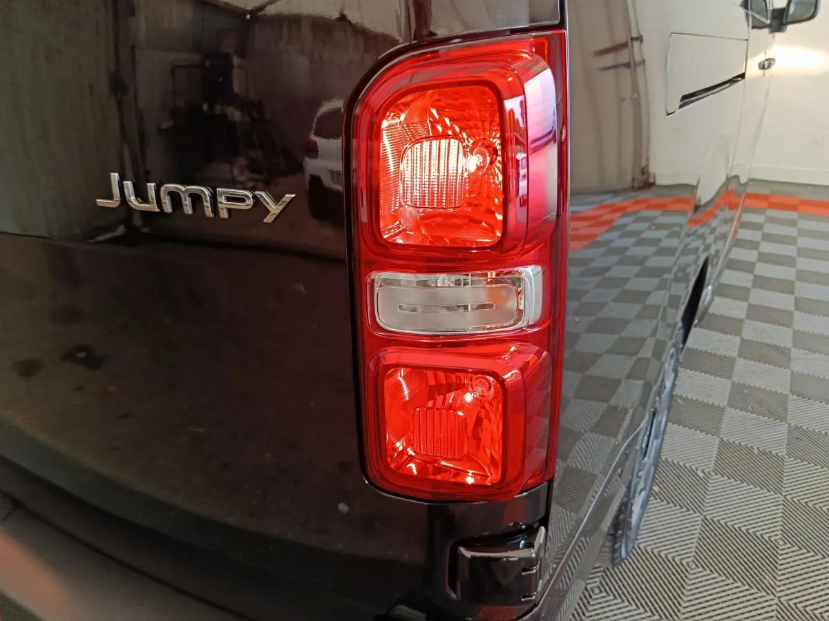 Gros plan sur le feu arrière droit et le logo Jumpy d’un Citroën Jumpy XL noir, vue arrière côté droit.
