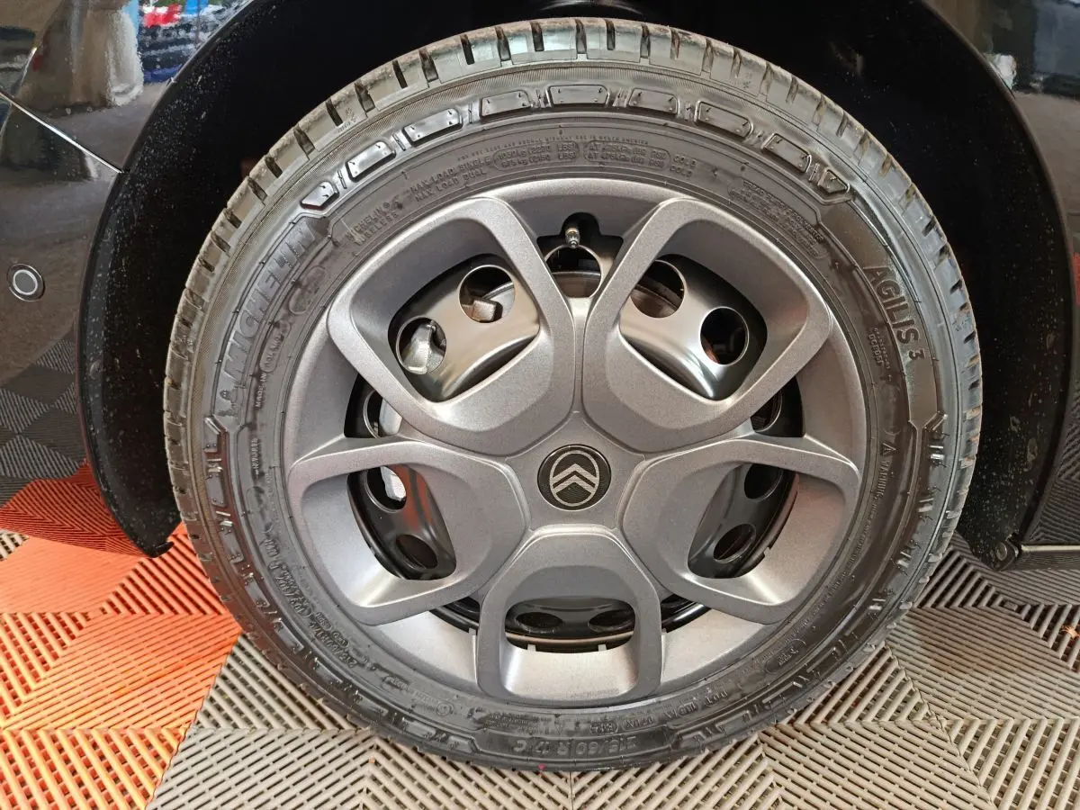 Gros plan sur la roue arrière droite noire du Citroën Jumpy XL 2.2 Diesel 180 EAT8, avec capteur de stationnement visible.