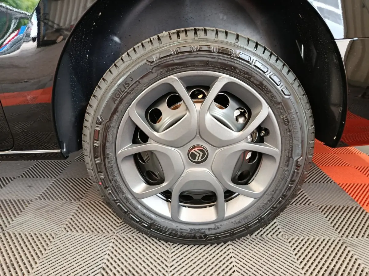 Gros plan sur la roue avant droite noire d’un Citroën Jumpy XL 2025, mettant en valeur la jante grise au design moderne.