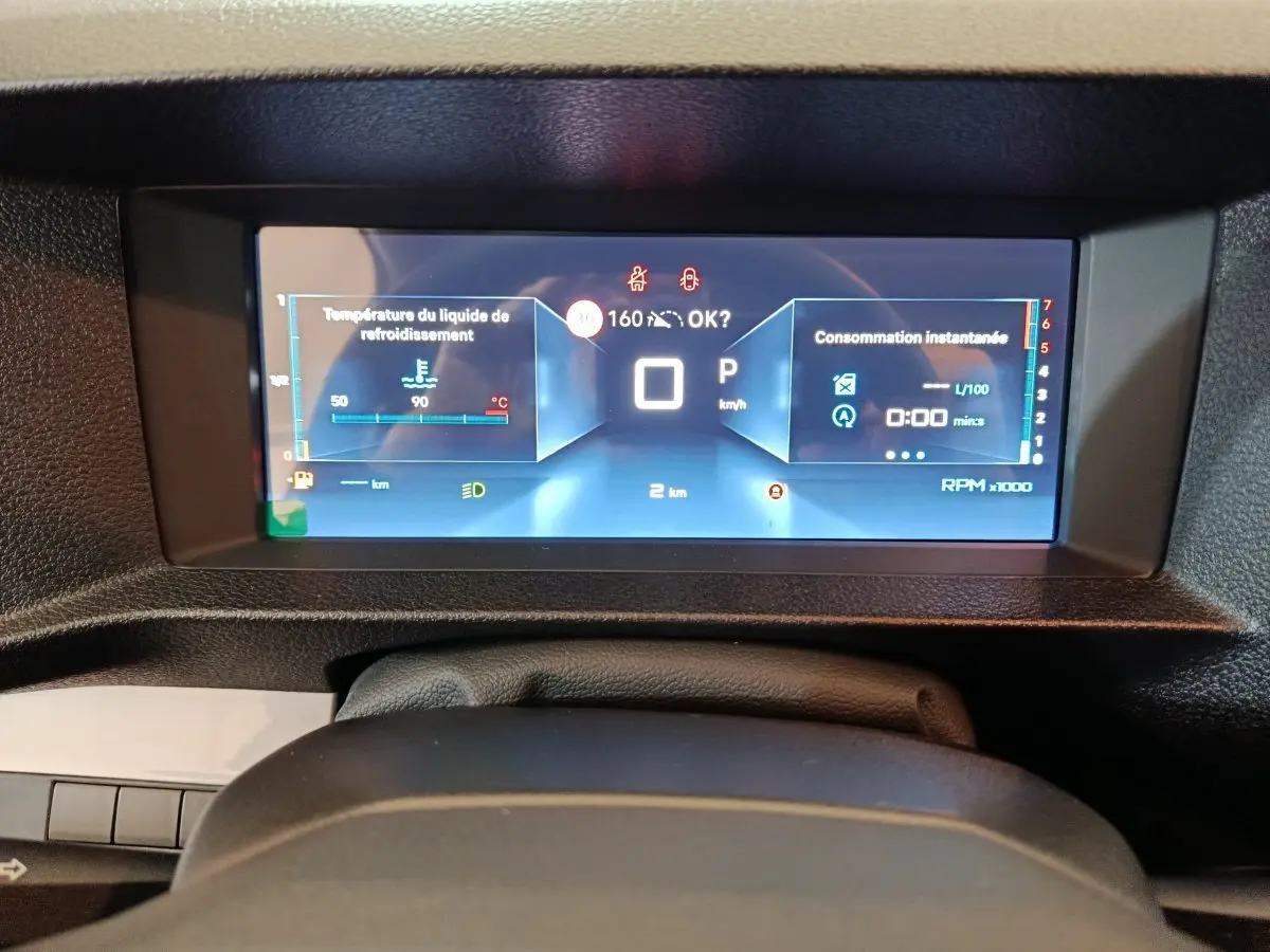 Vue rapprochée du tableau de bord numérique du Citroën Jumpy noir, affichant la température moteur et la consommation instantanée.