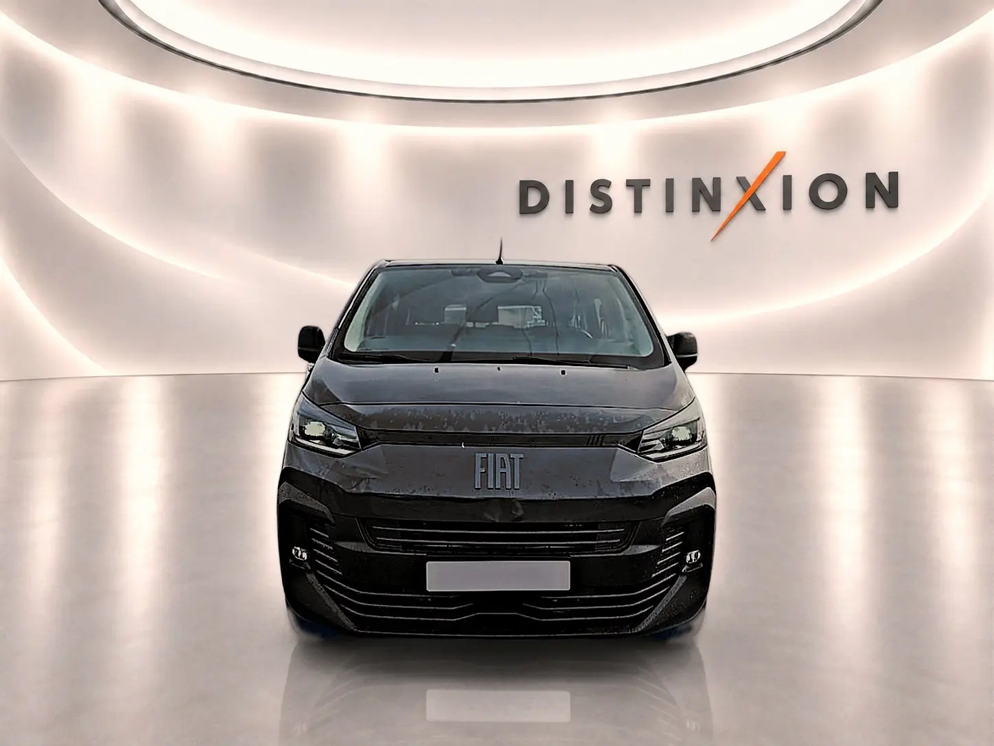 Vue avant du FIAT Scudo Combi gris titane dans un showroom lumineux avec logo Distinxion en arrière-plan.