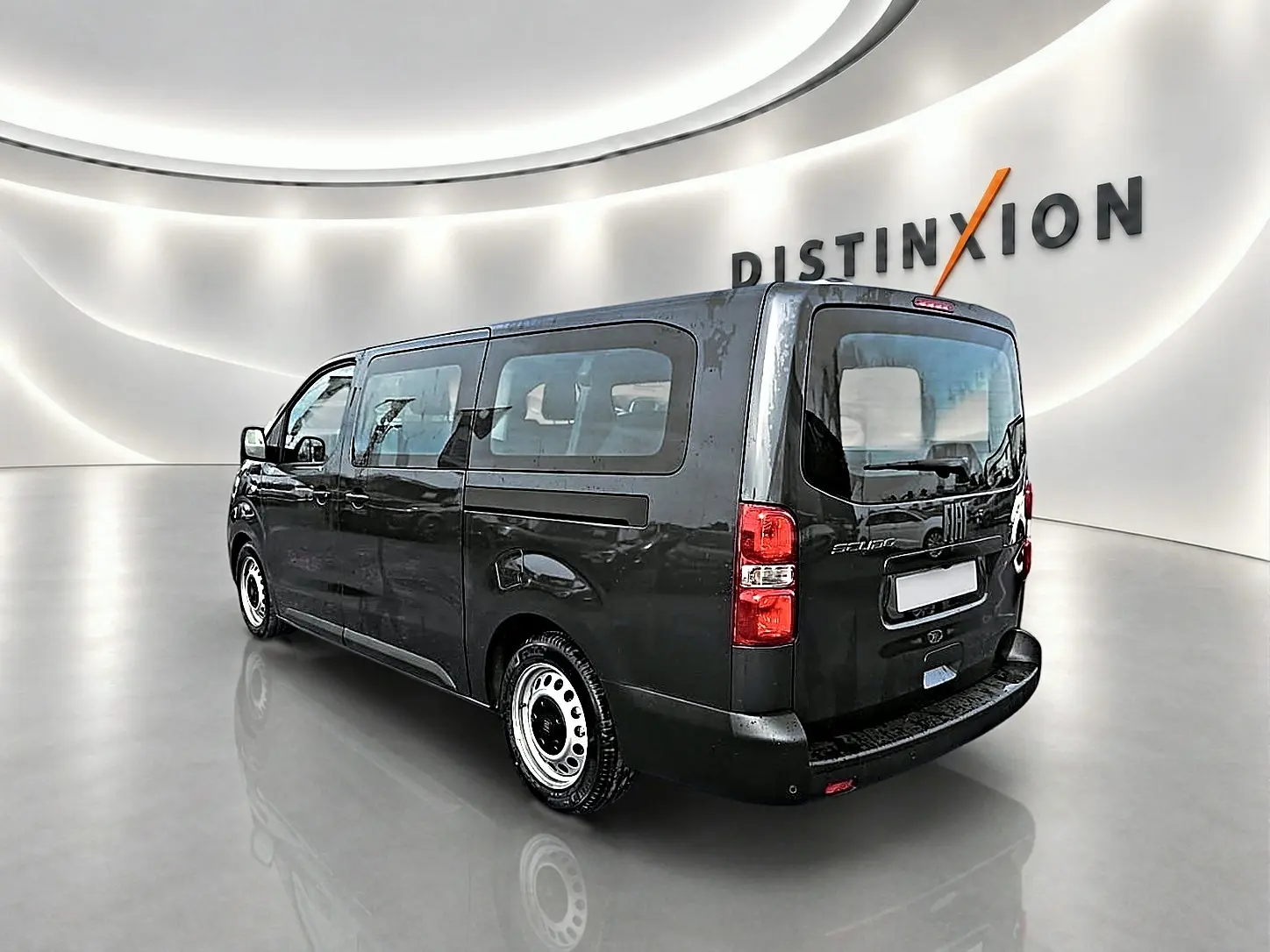 Vue 3/4 arrière droite d'un FIAT Scudo Combi gris titane avec porte latérale coulissante dans un showroom lumineux.