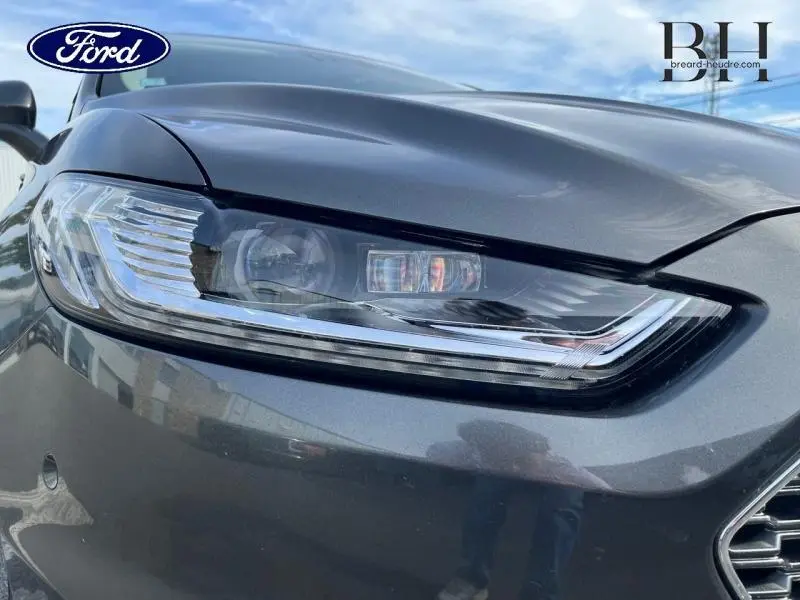 Gros plan sur le phare avant droit gris Magnetic de la Ford Mondeo 2018 avec calandre chromée visible