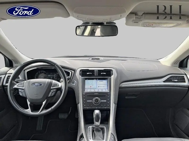 Vue frontale de l'habitacle de la Ford Mondeo gris Magnetic, avec tableau de bord et écran tactile central visibles.