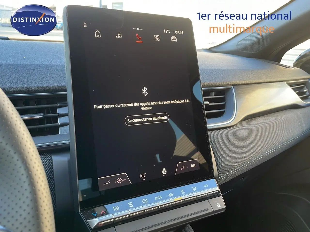 Vue intérieure du tableau de bord du Renault Captur E-Tech hybride 2025, avec écran tactile central allumé et volant partiel visible.