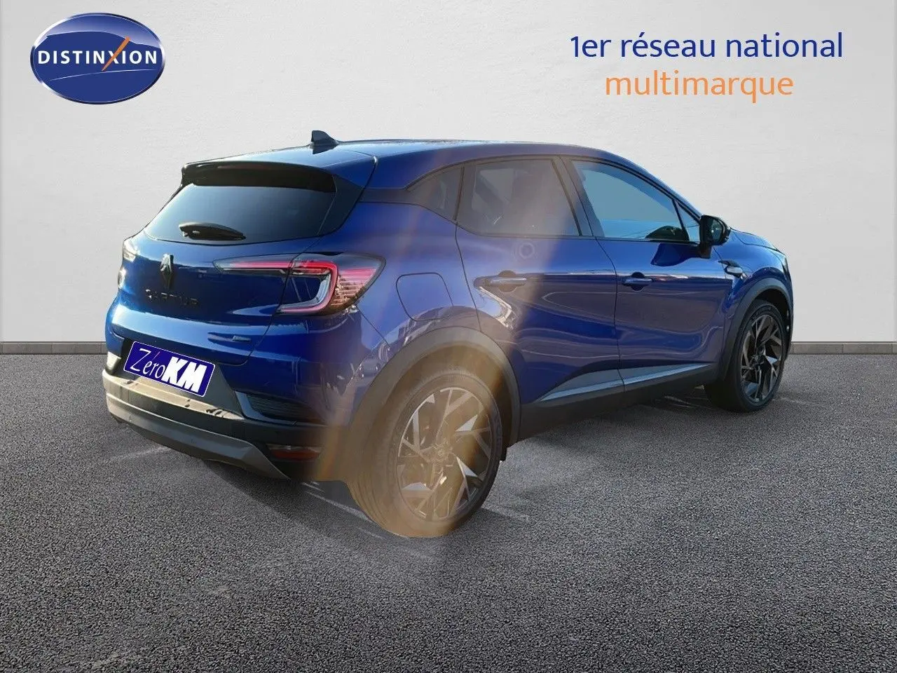 Renault Captur E-Tech hybride bleu Iron Metal avec toit noir, vue 3/4 arrière côté gauche, jantes noires distinctives.