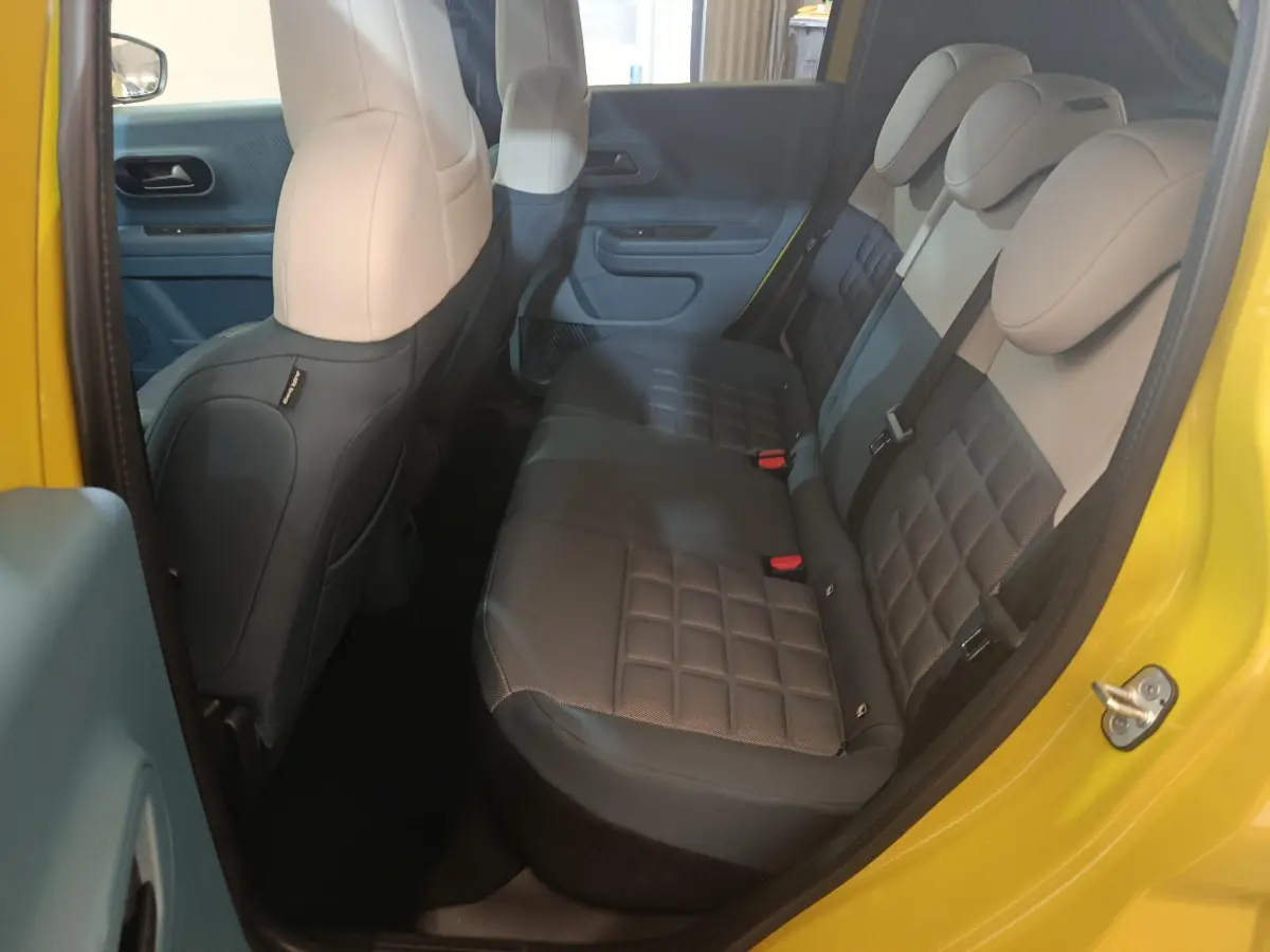 Vue intérieure côté droit de la banquette arrière bicolore beige et noir d'une FIAT Grande Panda jaune 2025.